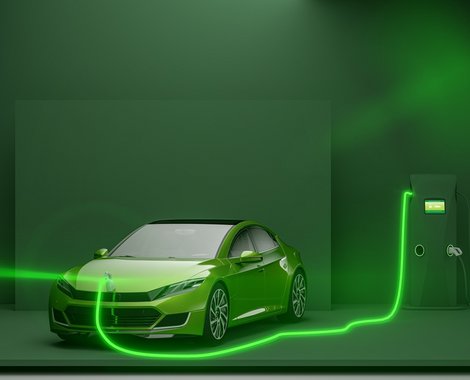 Grünes Elektroauto lädt an einer modernen Ladestation; neon-grüne Kabel beleuchten die Szene.